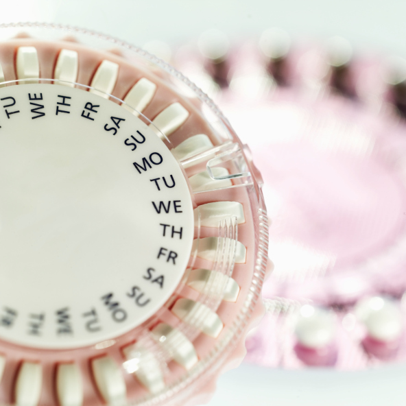 Close-up of birth control pills in two plastic tablet dispenser cases