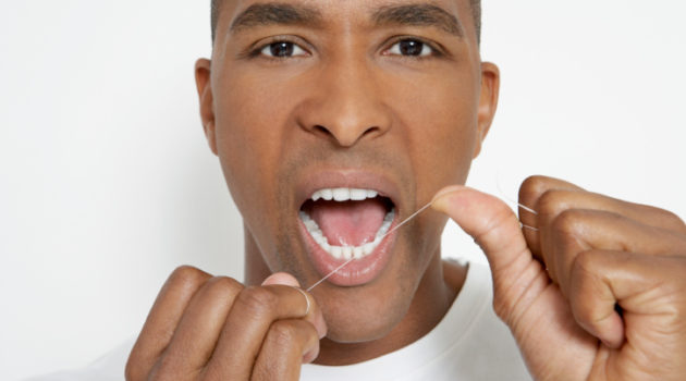 African American Black man flossing teeth