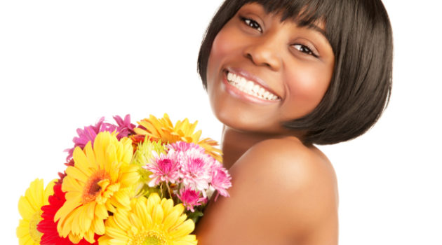 smiling african american woman holding a bouquet of flowers