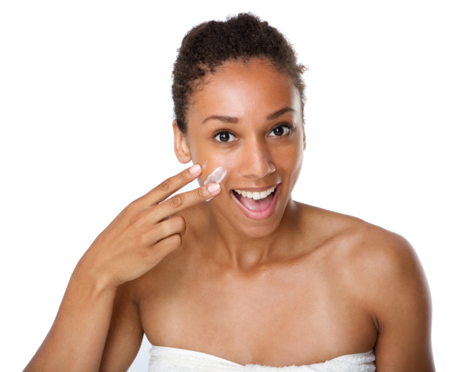 woman putting lotion on face
