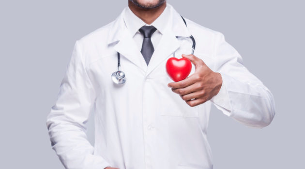 smiling doctor holding a red heart