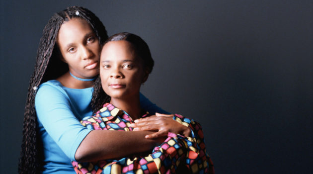 African American Black mother and daughter serious hugging