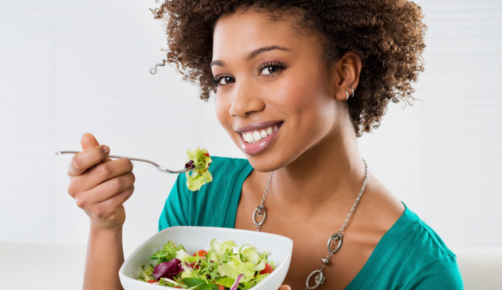 woman eating salad smiling