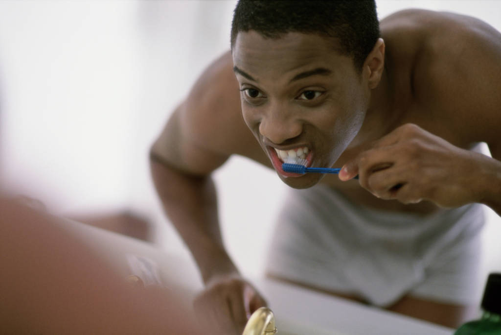 Close-up of a young man brushing his teeth