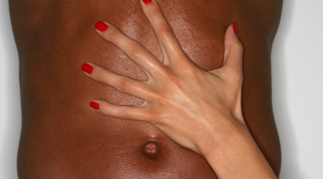 A ladies hand across a mans stomach