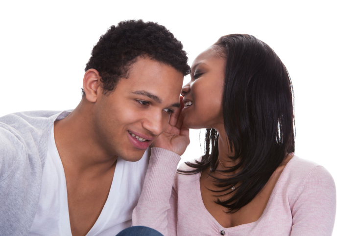 woman whispering into mans ear