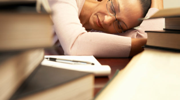 tired woman sleeping on a crowded desk