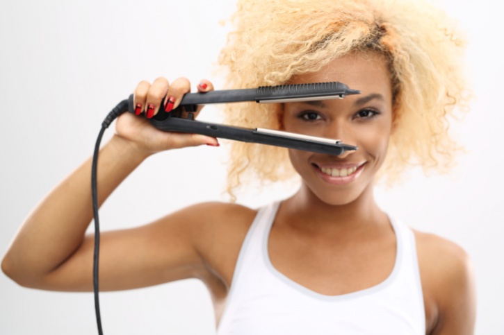 African American woman natural hair using flat iron