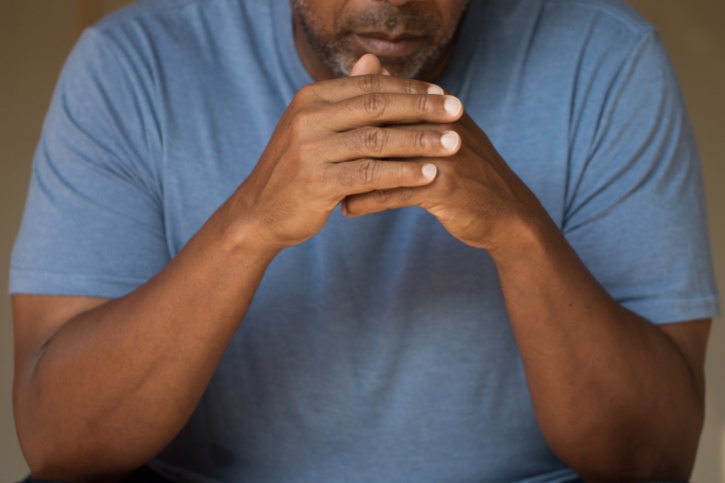 depressed man, hands folded