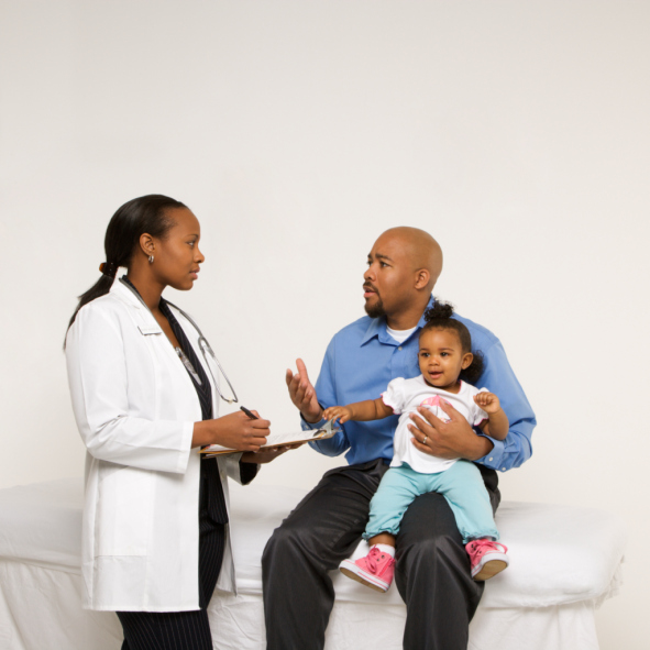father with baby talking to doctor