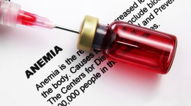 vial with needle sitting on top of a paper with the description of anemia typed on it