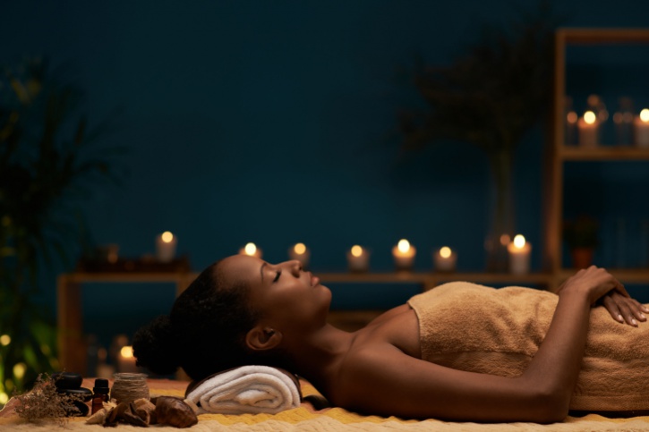 African American woman relaxing with candles
