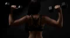 back profile of woman with weights in both hands