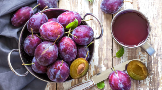 Bowl of plums cup of plum juice