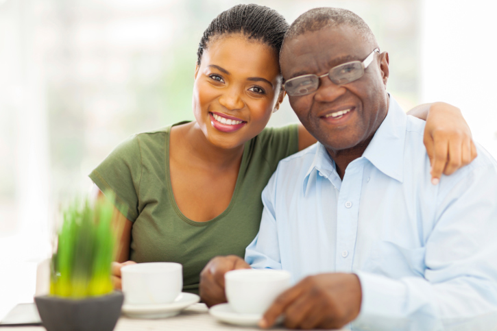 African American Black young woman and older father having coffee