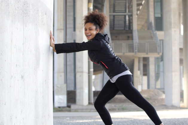 African American Black woman stretching exercise outdoors leggings