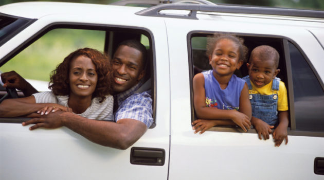 African American Black family with two children riding in SUV truck