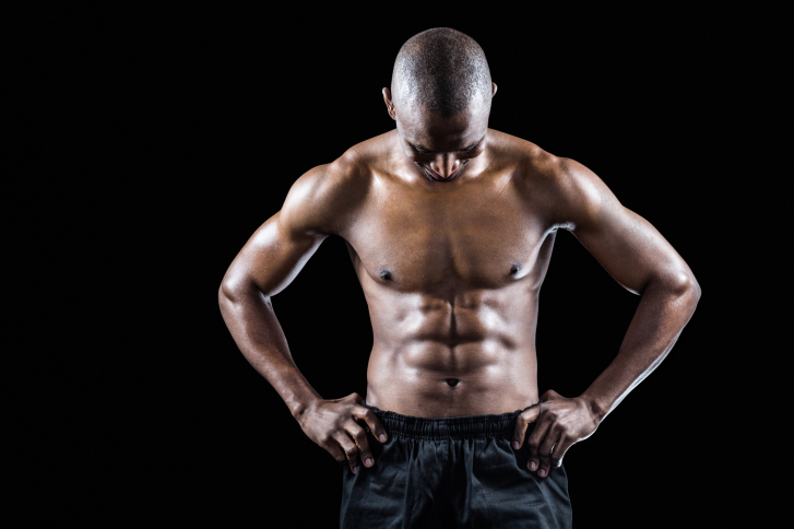 Homme musclé avec la main sur la hanche regardant vers le bas