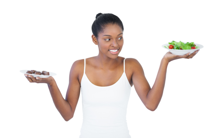 African American Black woman deciding between chocolate and salad