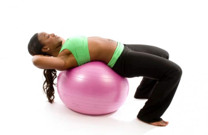 African American woman doing crunches on stability ball