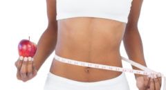 African American thin woman measuring waist