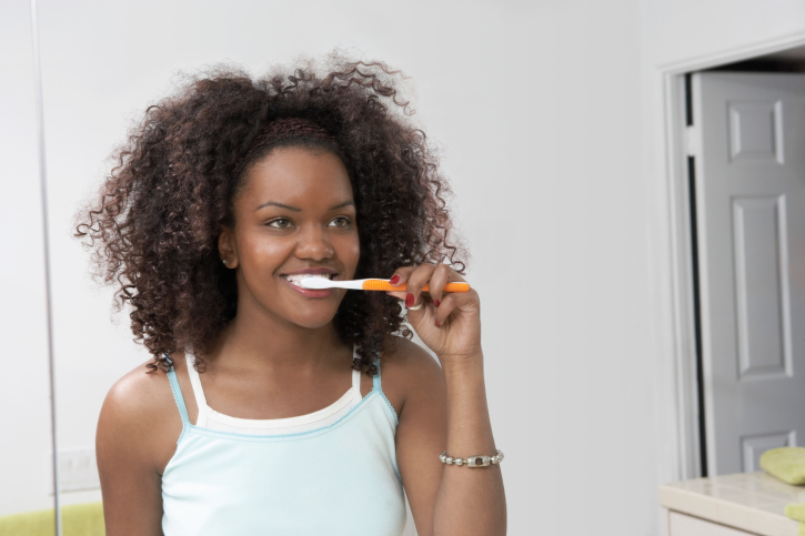 African American woman brushing teeth