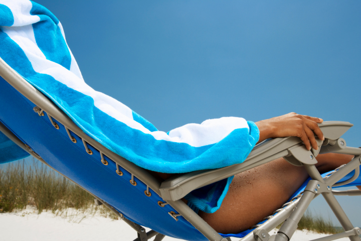 African American woman in beach chair covered with towel