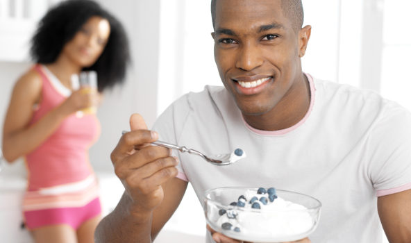 African American man eating yogurt