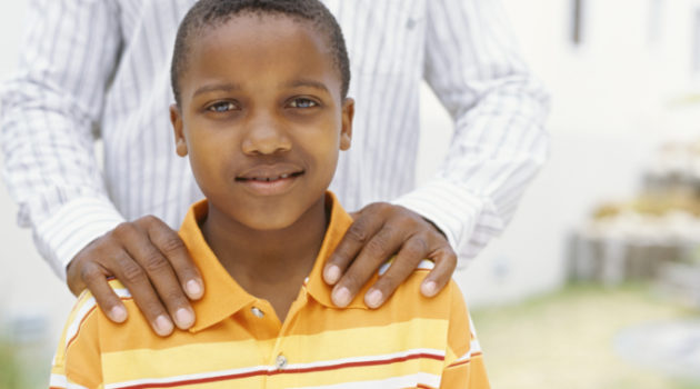 African American boy standing with father