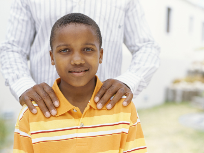 African American boy standing with father