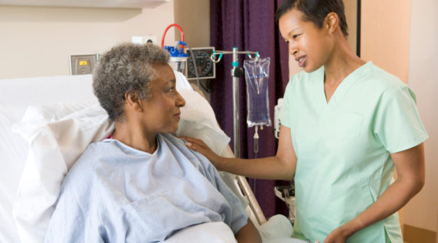 African American nurse talking to senior woman in hospital