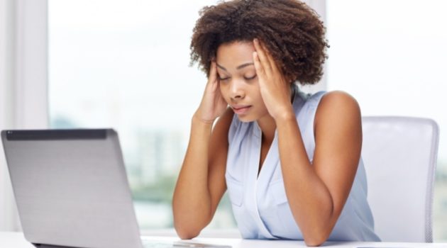 African American woman with headache on laptop