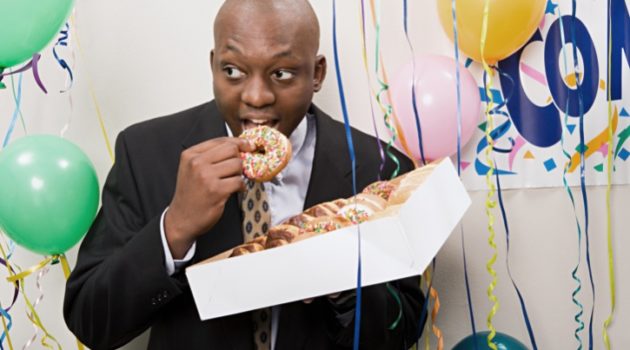 African American man secretly eating box of donuts