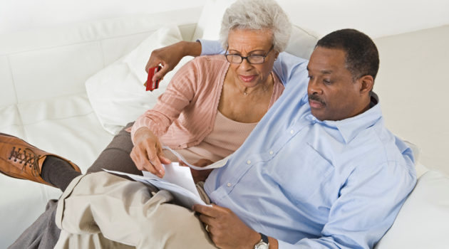 Senior couple on couch with paperwork