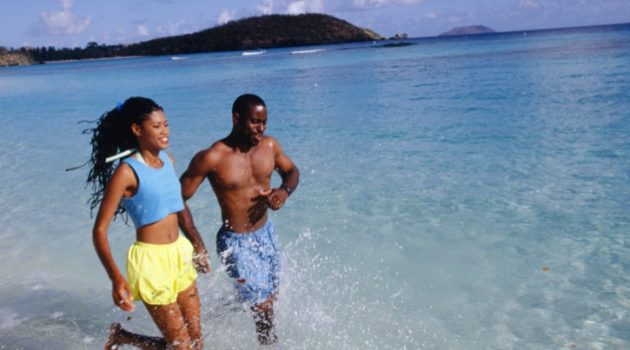 African American couple running in water beach