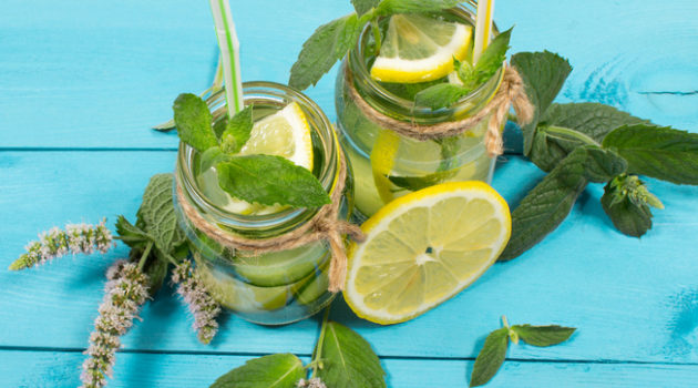 Water with fresh lemon, green leaves mint and cucumber