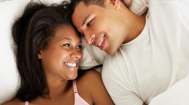 African American couple relaxing in bed