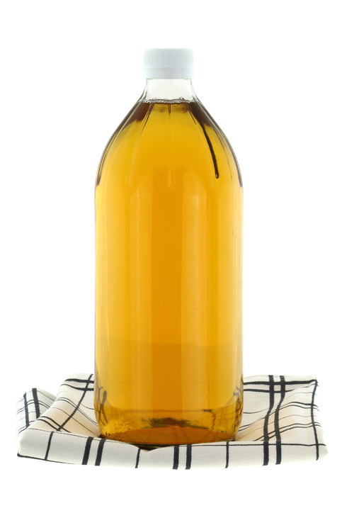 A bottle of filtered Apple Cider Vinegar isolated on white