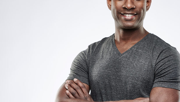African American man smiling with arms folded