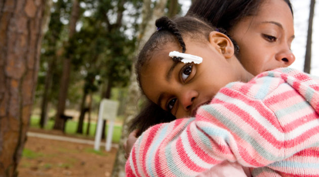 African American mother hugging daughter