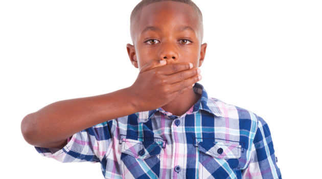 African American boy covering mouth