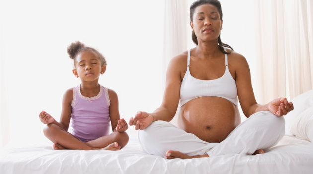 African American mother and daughter meditating