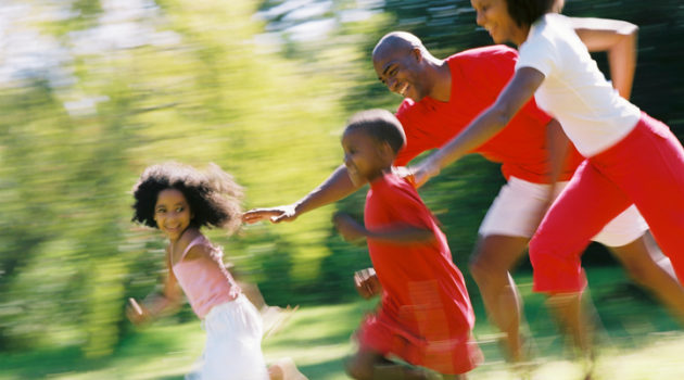 African American parents chasing children outside