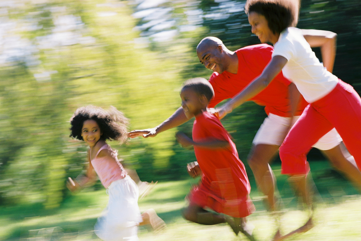 African American parents chasing children outside