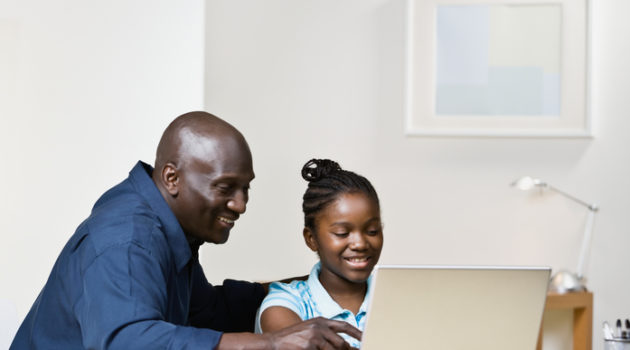 African American father and daughter on laptop