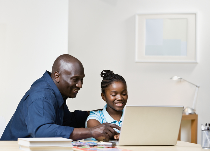 African American father and daughter on laptop