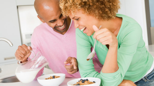 African American couple eating cereal breakfast