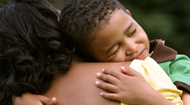 African American mother hugging upset son