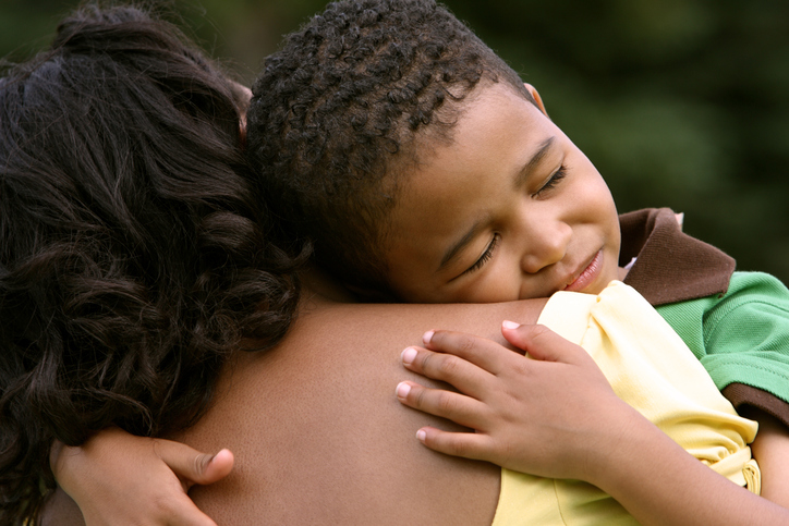 African American mother hugging upset son