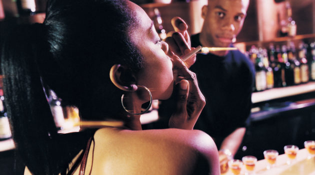 African American woman smoking in bar